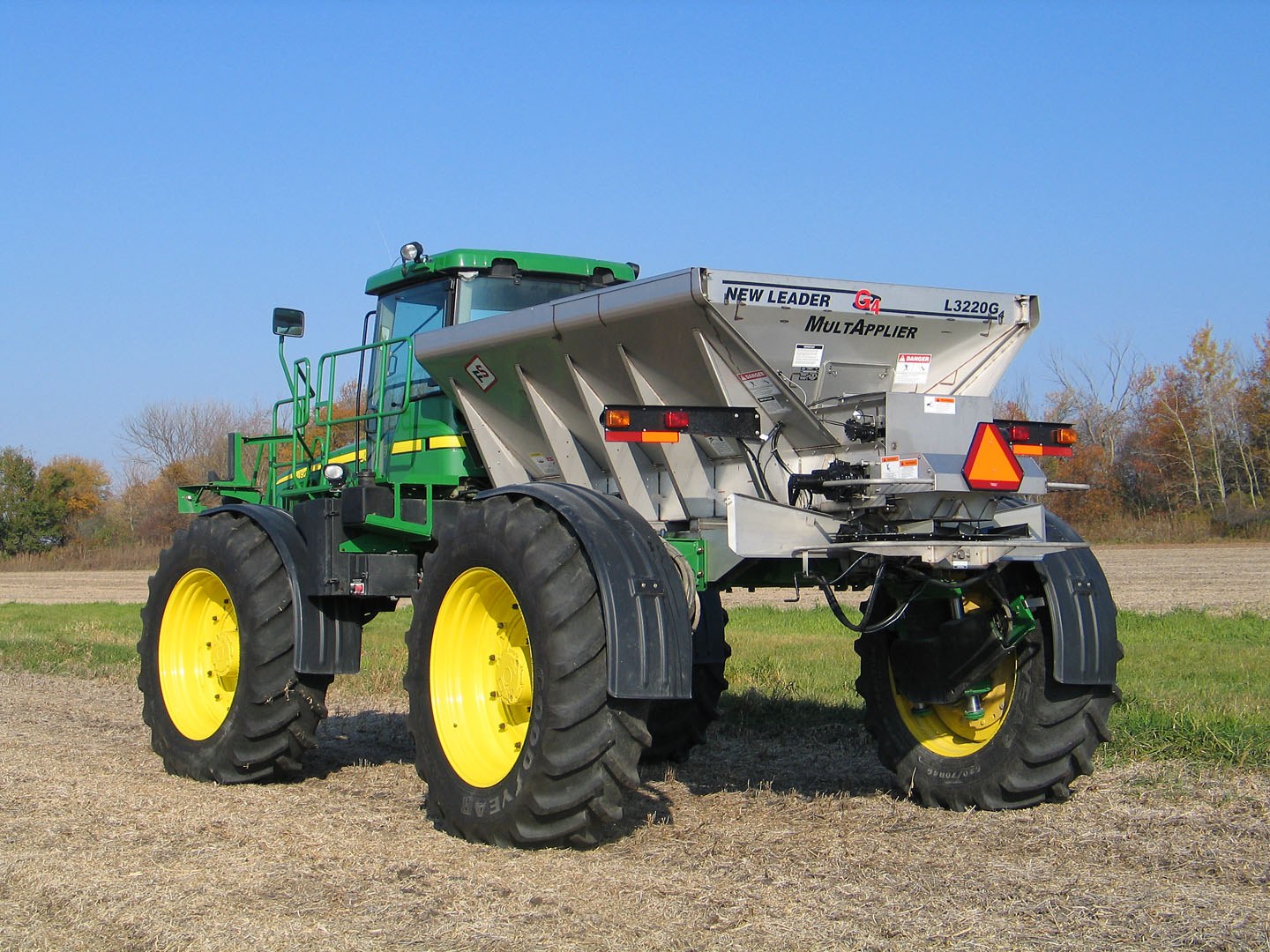A New Leader MultApplier spreader body on a self-propelled John Deere chassis, in a field of stubble